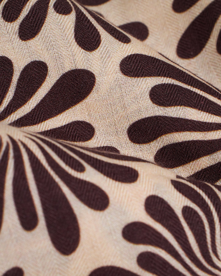 A close up of The Amalfi Woven Ascot - Carajillo Fleur by Dandy Del Mar, a brown and tan fabric.