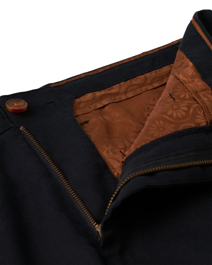 A close up of the Dandy Del Mar Brisa Linen Trouser - Onyx with brown zippers.