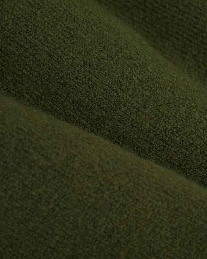 A close up of the Lima Sweater - Selva by Dandy Del Mar, an olive green sweater.