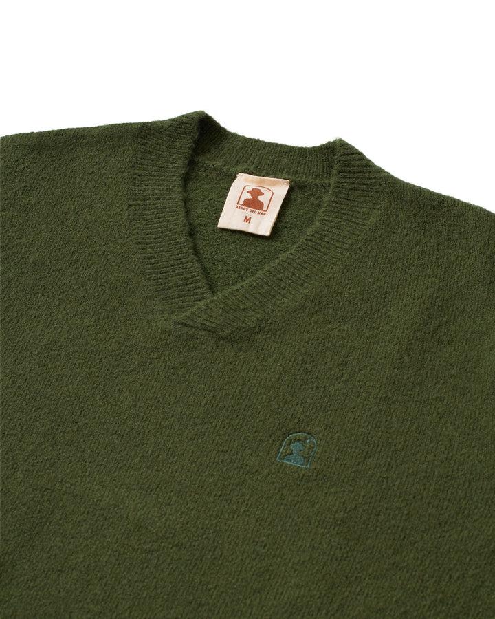 A green Lima Sweater - Selva from Dandy Del Mar with a logo on it.