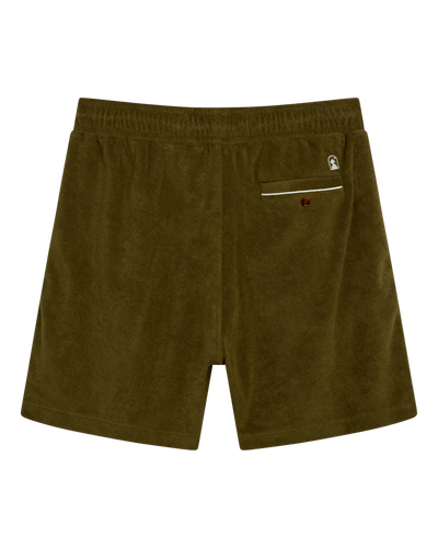 Back view of Dandy Del Mar’s Gaucho Terry Cloth Shorts in Arbequina: olive green leisure shorts with an elastic waistband, a single back pocket with button closure, and a small embroidered logo—ideal for relaxed days.