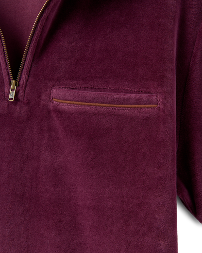 Close-up of The Rio Velour Shirt - Bordeaux by Dandy Del Mar, a maroon polo shirt with velour fabric, antique brass zipper, and a single chest pocket featuring a matching zipper detail.