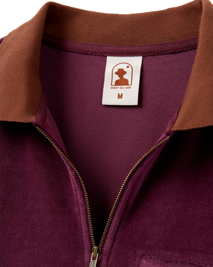 Close-up of The Rio Velour Shirt - Bordeaux by Dandy Del Mar, a maroon and brown luxury velour polo with a 3/4 zip design and visible size medium label.