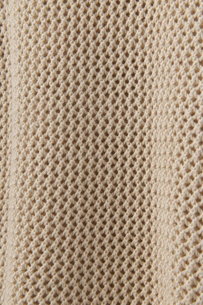 Close-up of The Porto Crochet Tank in Sabbia by Dandy Del Mar, highlighting its beige, textured, waffle-knit fabric with a grid-like open-knit pattern.