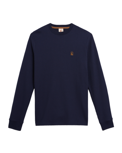 The Dandy Del Mar Cannes Long Sleeve Shirt in Luxe Navy, crafted from waffle knit fabric with a small brown embroidered logo on the left chest, is displayed flat on a white background.