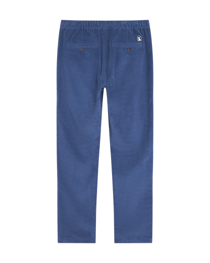 The Corsica Corduroy Pant - Moontide by Dandy Del Mar, shown from the back in blue 8-wale corduroy, features an elastic waist and two buttoned back pockets.