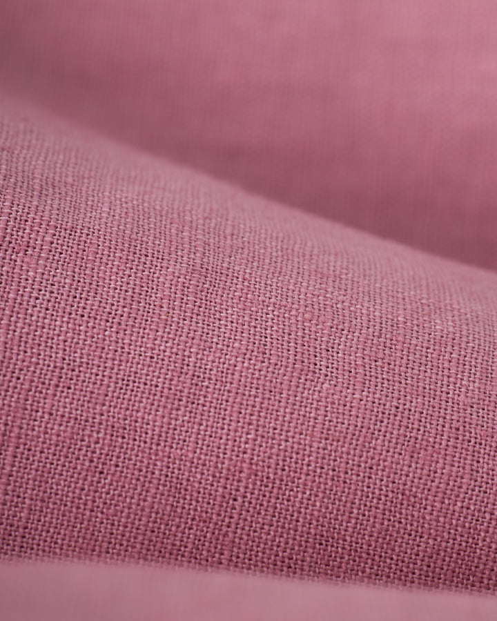 Close-up of Dawn pink fabric with smooth texture and a slight weave pattern, reminiscent of The Brisa Linen Pant by Dandy Del Mar, ideal for vacation pants.