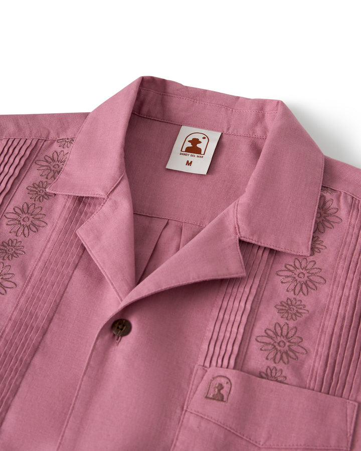 The Brisa Linen Shirt - Dawn by Dandy Del Mar is a pink collared shirt with floral embroidery on the chest and sleeves, shown in medium size.