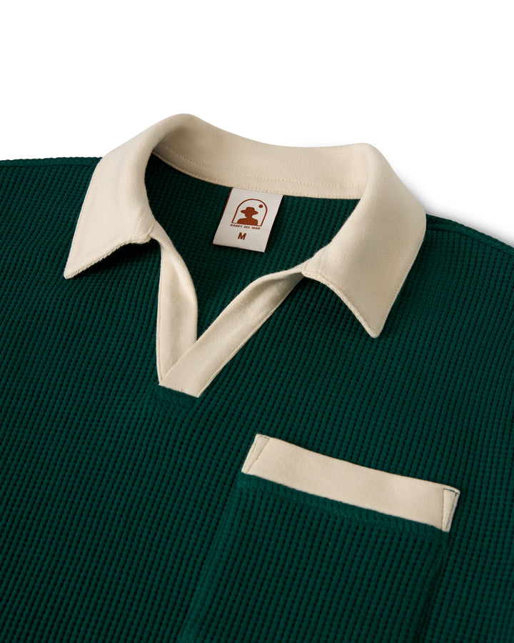 The Cannes Waffle Knit Shirt - Albero by Dandy Del Mar is a green collared shirt with white detailing on the collar and pocket, and a small logo inside the collar.