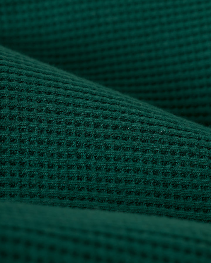 Close-up of The Cannes Waffle Knit Robe - Albero by Dandy Del Mar, highlighting its green waffle-textured pattern and texture.