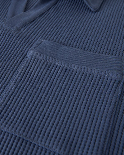 Close-up of the Dandy Del Mar Cannes Waffle Knit Polo Shirt in Moontide, featuring a collar and patch pocket.