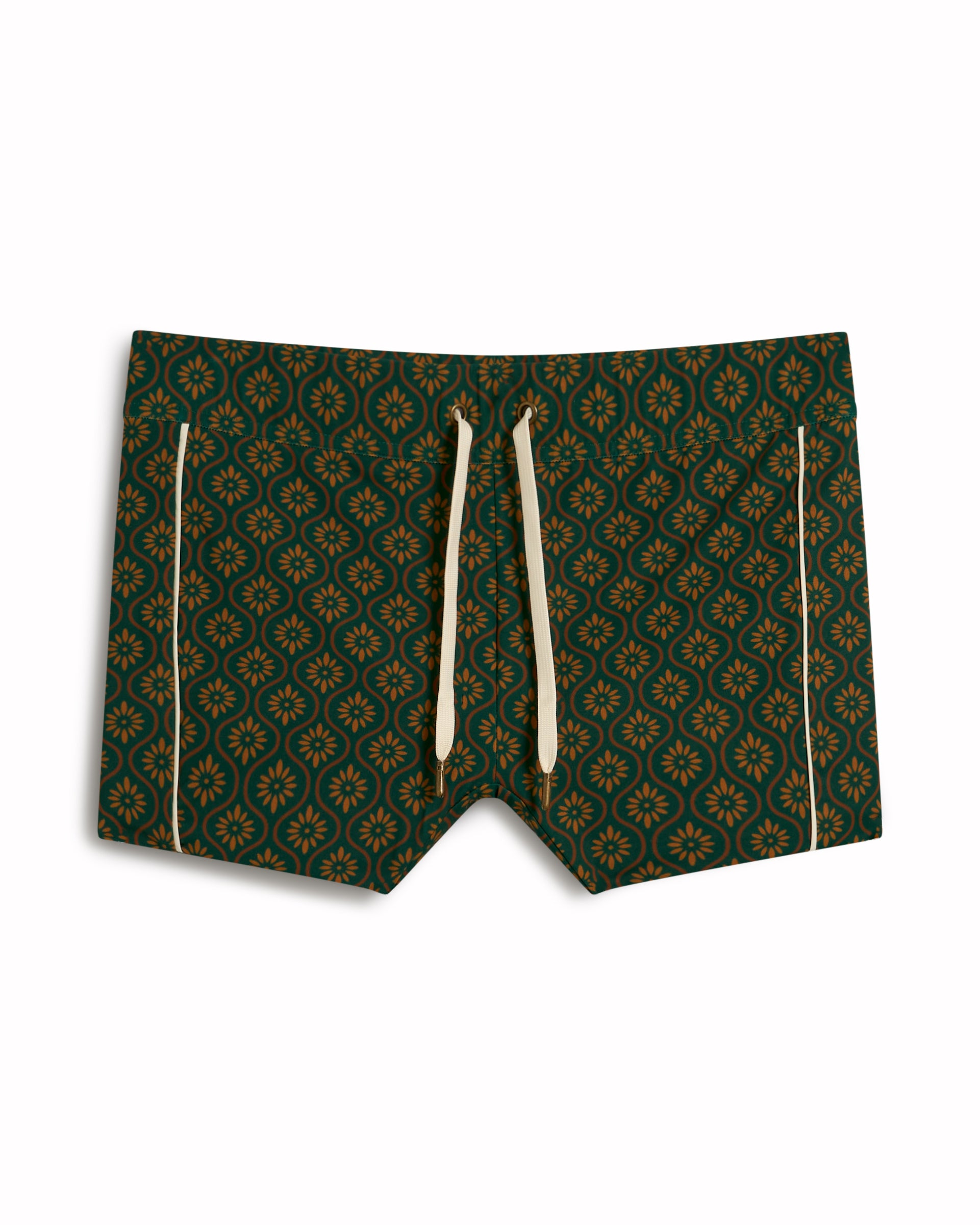 The Cassis Square Cut Swim Brief - Albero by Dandy Del Mar features a green European fit with a gold floral pattern and cream drawstrings. Made from recycled polyester, these swim trunks blend style and sustainability for the modern swimmer.