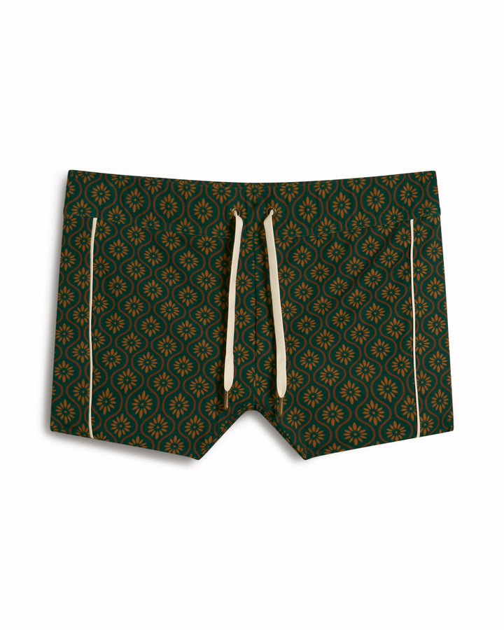 The Cassis Square-Cut Swim Brief - Albero by Dandy Del Mar features green patterns, yellow drawstrings, and side stripes.