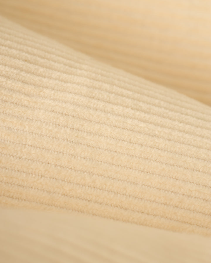 Close-up of The Corsica Corduroy Short in Scallop by Dandy Del Mar, featuring a beige ribbed texture with subtle horizontal lines.