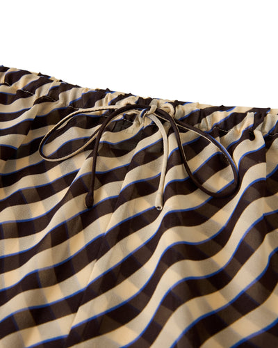 Close-up of the relaxed fit elastic waistband with drawstring on The Curacao Shorts - Tierra by Dandy Del Mar, featuring wavy brown, beige, and blue stripes.