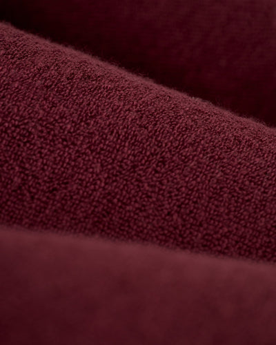 Close-up of The Gaucho Shirt in Bordeaux by Dandy Del Mar, showcasing a maroon terry cloth texture with soft horizontal folds that evoke an Equatorial Cowboy look.
