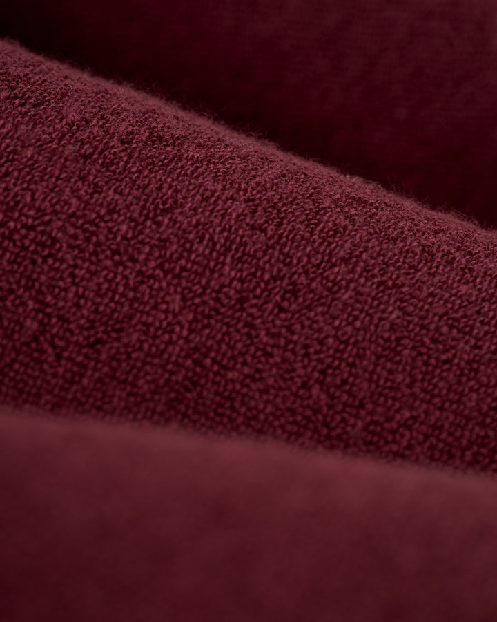 Close-up view of "The Gaucho Terry Cloth Shirt - Bordeaux" by Dandy Del Mar, featuring soft, fuzzy textured fabric in burgundy with layered folds.