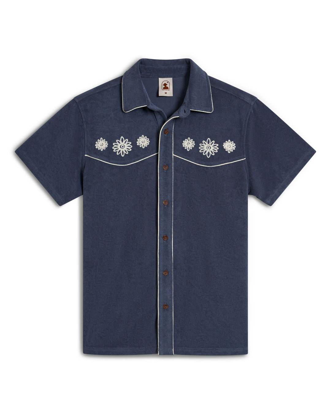 A short-sleeved blue Gaucho Terry Cloth Shirt by Dandy Del Mar features floral embroidery on the chest and white piping on the collar and pockets.