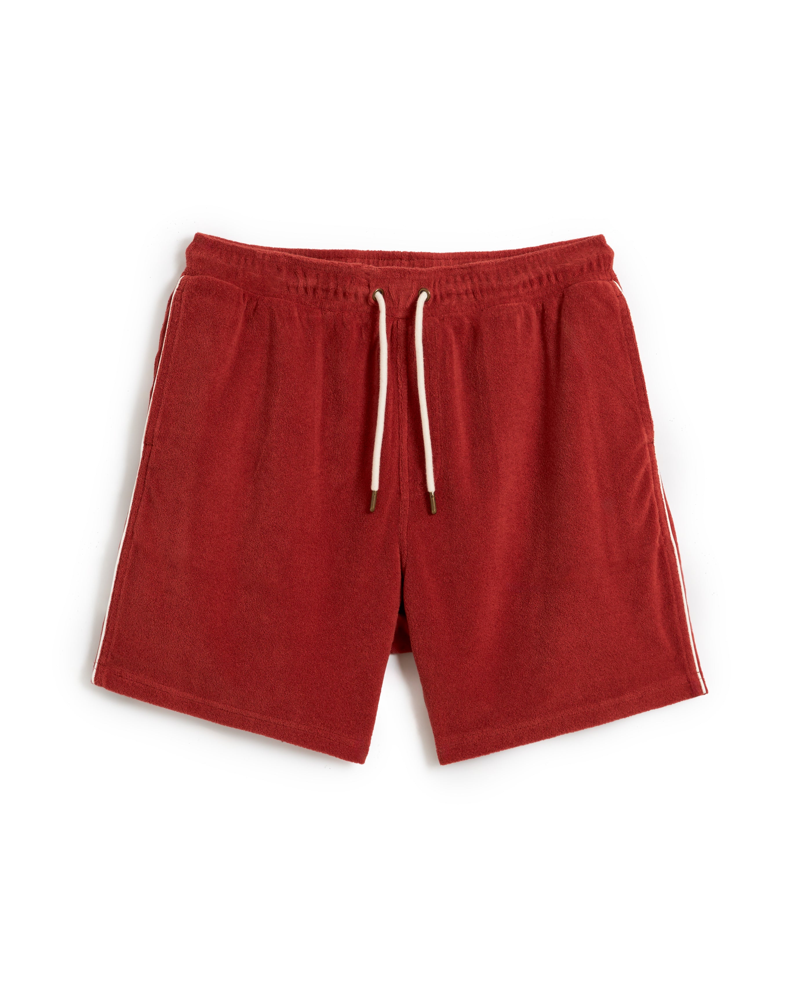 The Gaucho Short - Rouge by Dandy Del Mar features an elastic waistband, white drawstrings, and sleek side stripes in terry cloth. Laid flat on a pristine white background, these shorts exude casual comfort and effortless style.