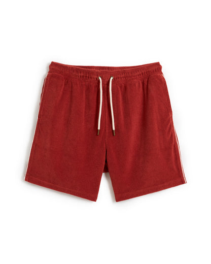 The Gaucho Short - Rouge by Dandy Del Mar features an elastic waistband, white drawstrings, and sleek side stripes in terry cloth. Laid flat on a pristine white background, these shorts exude casual comfort and effortless style.