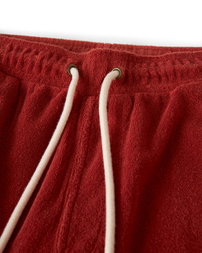 Close-up of The Gaucho Short - Rouge by Dandy Del Mar, showcasing red terry cloth shorts with white drawstrings through metal eyelets on an elastic waistband.