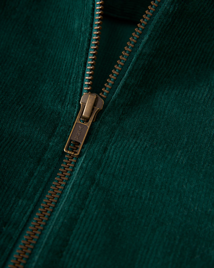 A close-up of a bronze zipper on the textured surface of The Kitts Corduroy Dress in Albero, crafted by Dandy Del Mar.