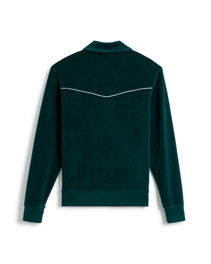 Back view of The Rio Velour Jacket - Albero by Dandy Del Mar, a dark green long-sleeve jacket reminiscent of a classic track jacket, with white piping detail across the upper back.