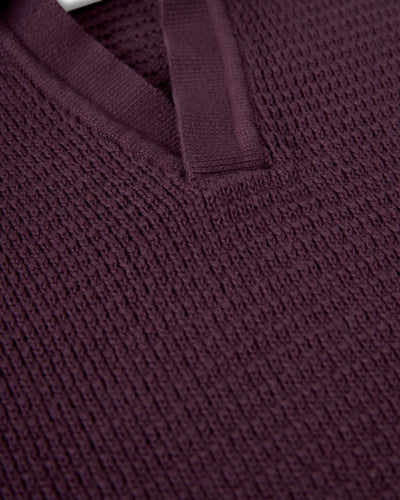 Close-up of The Sebastian LS Polo Shirt in Amethyst by Dandy Del Mar, featuring textured knit, V-neckline, and ribbed trim that highlight the refined details of modern men’s knitwear.