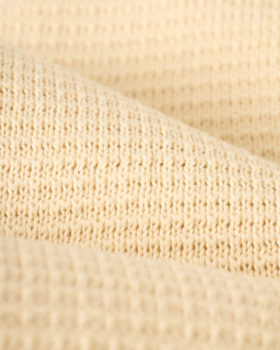 Close-up of The Sebastian Long Sleeve Polo in Vintage Ivory by Dandy Del Mar, highlighting its textured sweater-knit cotton and refined finish.