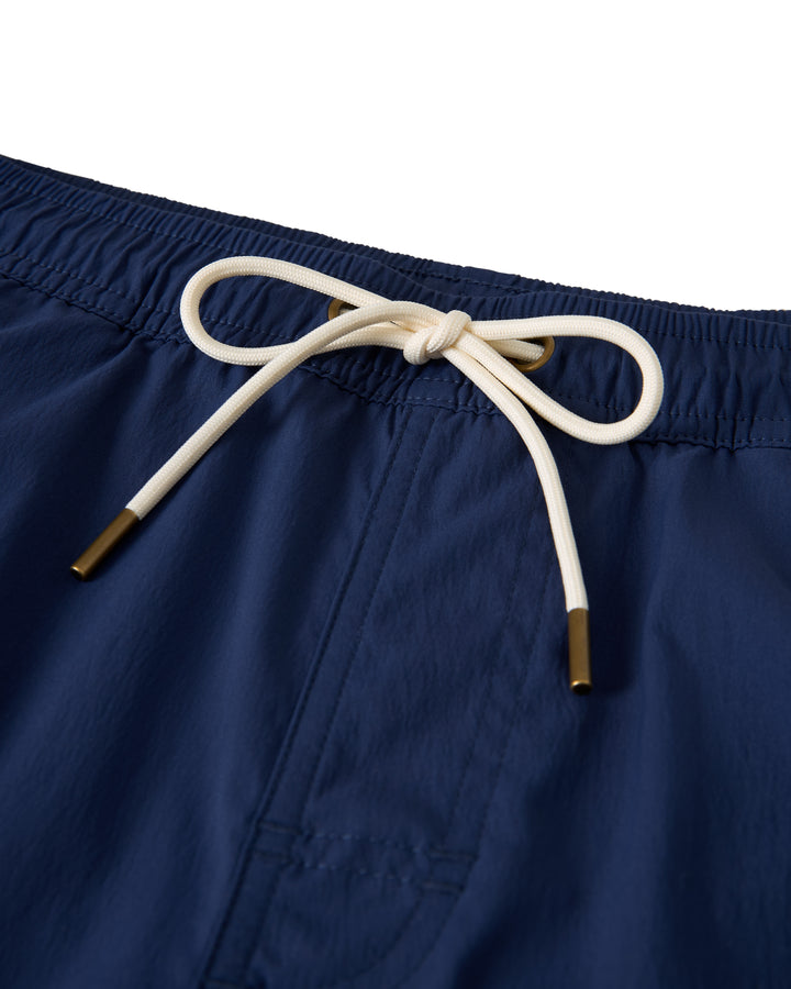 Close-up of The Ventura Volley Short - Anchor by Dandy Del Mar, featuring navy blue fabric, an elastic waist with a white drawstring and gold tips, and a micro mesh liner against a white background.