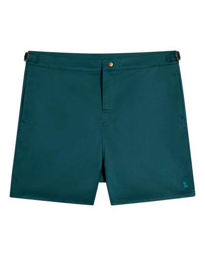 The Mallorca Swim-Walk Short - Tempest Blue by Dandy Del Mar features adjustable side fasteners, a button closure, and a small embroidered logo on the lower left leg.