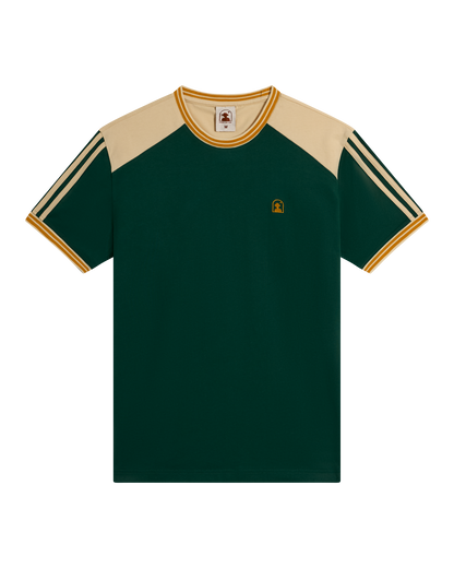 The Nassau Tee - Albero by Dandy Del Mar is a green short-sleeve cotton jersey with beige shoulders, striped sleeves, yellow trim on the collar and cuffs, and a small embroidered logo on the left chest.