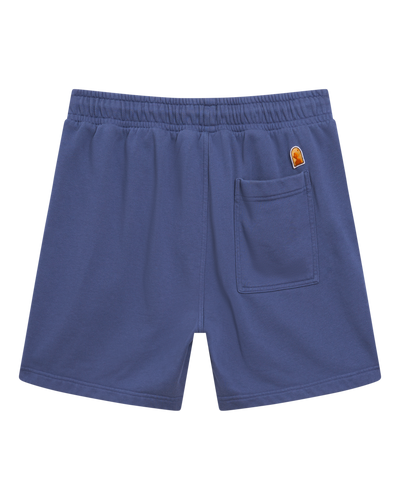 The Marseille French Terry Shorts - Moontide by Dandy Del Mar feature blue French terry fabric, an elastic waistband, a right back pocket, and a small patch logo above the pocket, shown on a plain white background.