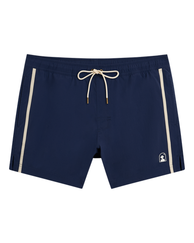 The Ventura Volley Shorts - Anchor by Dandy Del Mar are navy blue with beige side stripes, an elastic waistband, beige drawstring, and a small white logo on the left leg—ideal for stylish men’s swimwear.