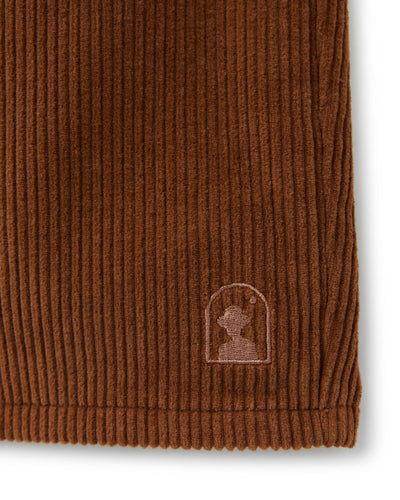 Close-up of The Corsica Corduroy Shorts - Tobacco by Dandy Del Mar, featuring a stitched silhouette inside an arch on the hem—ideal men's casual shorts for everyday style.