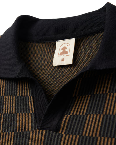 Close-up of The Sebastian Knit Polo Shirt - Onyx by Dandy Del Mar, featuring a brown and black checkered pattern, a collared design reminiscent of Italian knit polos, and a visible brand label showing size M.
